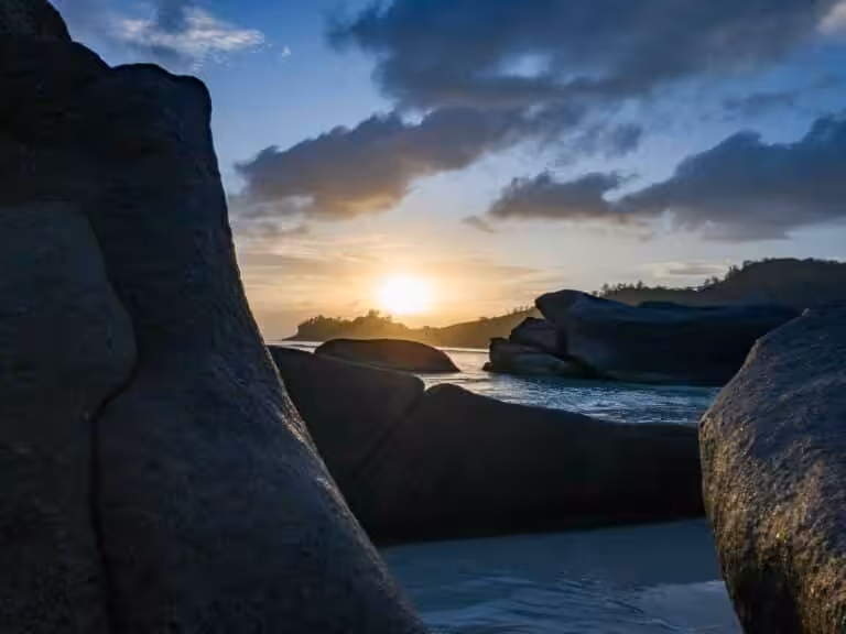 Sunset over granite rocks and tropical beach in the Seychelles