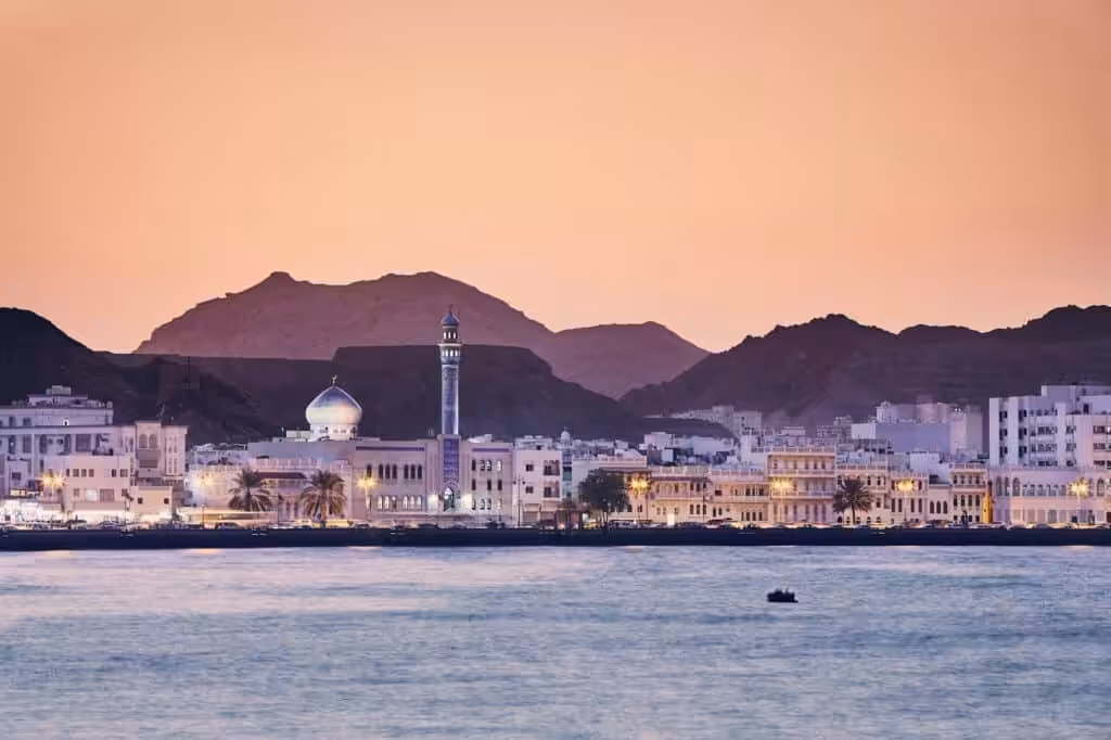 Muscat city skyline along the coast at sunset, Oman
