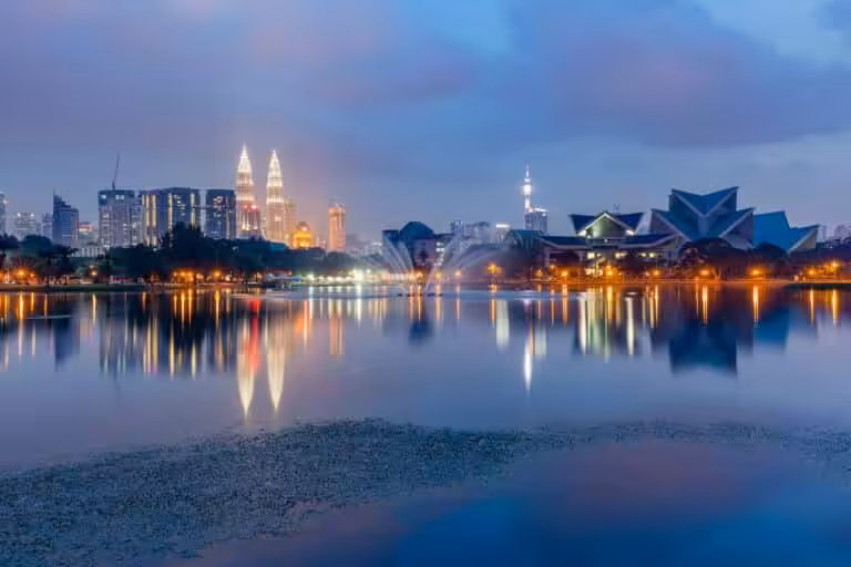Kuala Lumpur skyline at night, reflected in the still waters of Titiwangsa Lake, Malaysia.