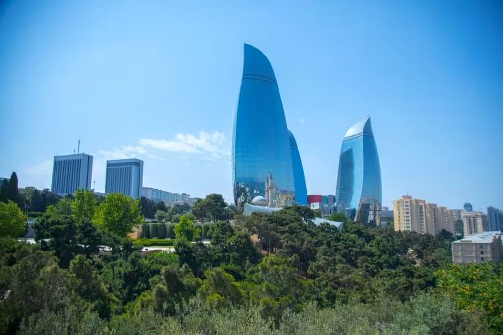 View of the Flame Towers in Baku from the seafront near Milli Park, with the Caspian Sea and promenade in the foreground.