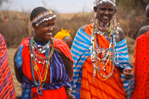 People wearing traditional Kenyan clothing with colorful fabrics, beadwork, and cultural patterns.
