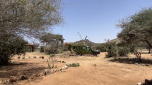 Safari lodge vehicle parked in a dry savanna landscape