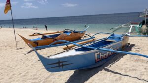 Colorful traditional banca boats on white sandy beach in the Philippines