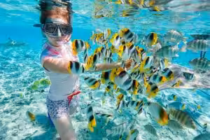 Woman snorkeling with tropical fish in clear turquoise water in Boracay Philippines