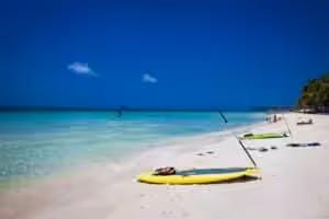 Stand up paddle board on white sand beach with turquoise water in Boracay Philippines