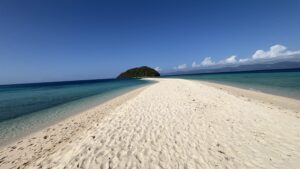 White sandbar leading to small island with turquoise water in Romblon, Philippines