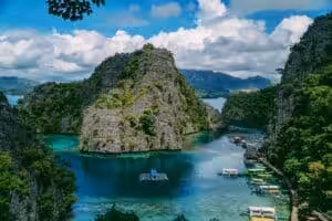 Coron lagoon with limestone cliffs and boats in Palawan, Philippines