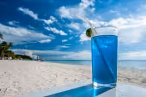 Blue tropical cocktail on beach table with ocean view in Boracay Philippines