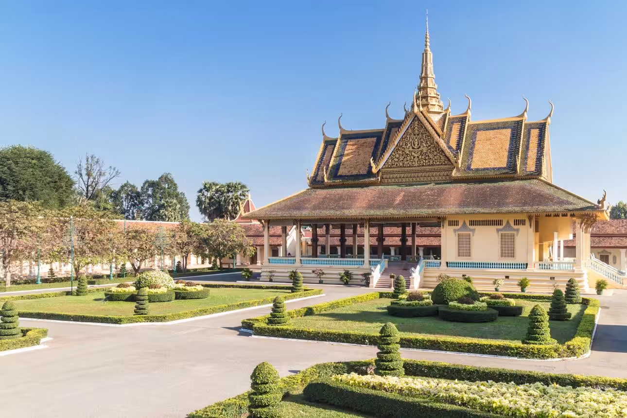 Traditional Khmer palace building with ornate roof and garden in Cambodia