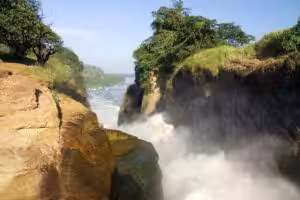 Powerful waterfall cascading through a narrow rocky gorge surrounded by greenery