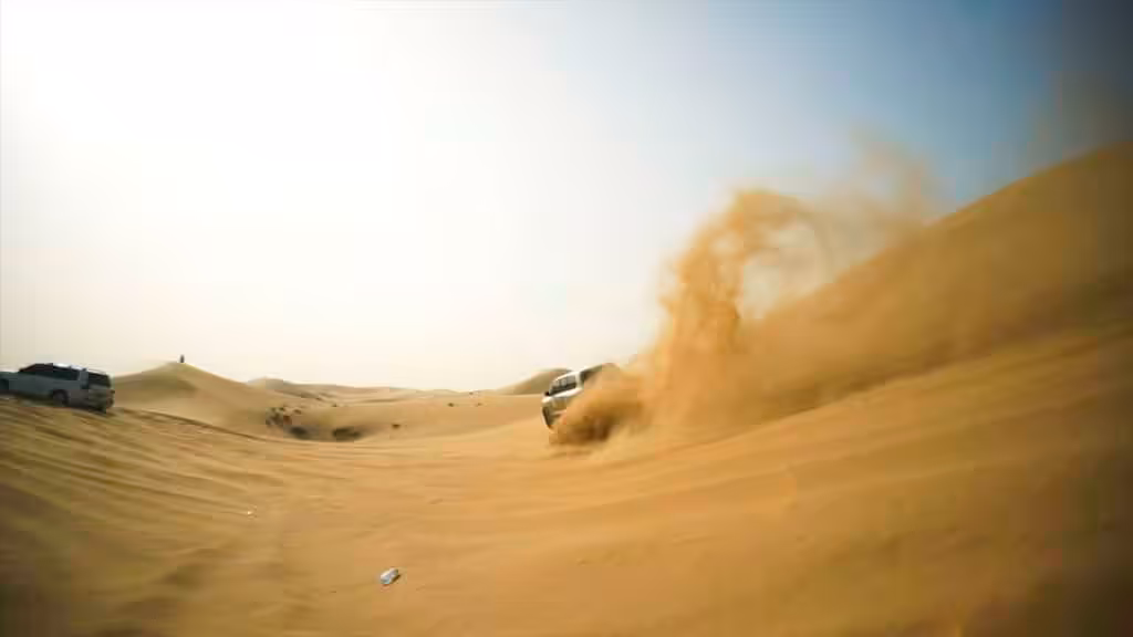 4x4 vehicles kicking up sand while dune bashing in the desert