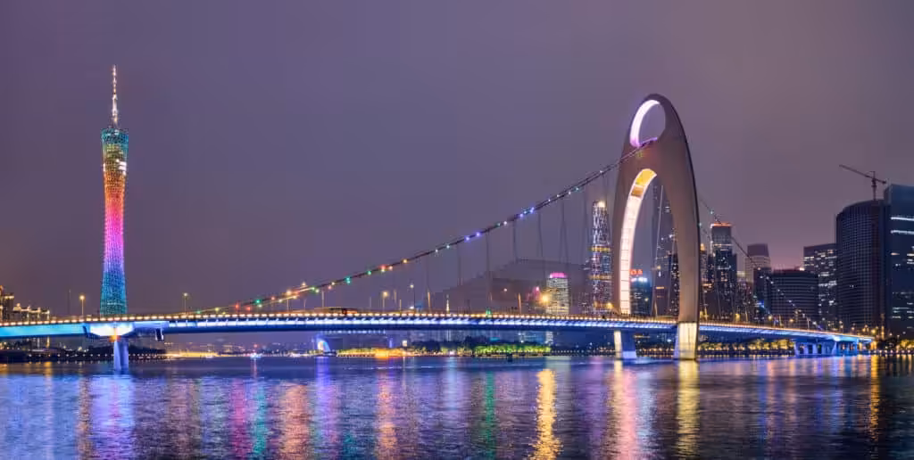 The illuminated Canton Tower and Liede Bridge reflected in the Pearl River at night, with the glittering Guangzhou city skyline in the background, Guangdong Province, China